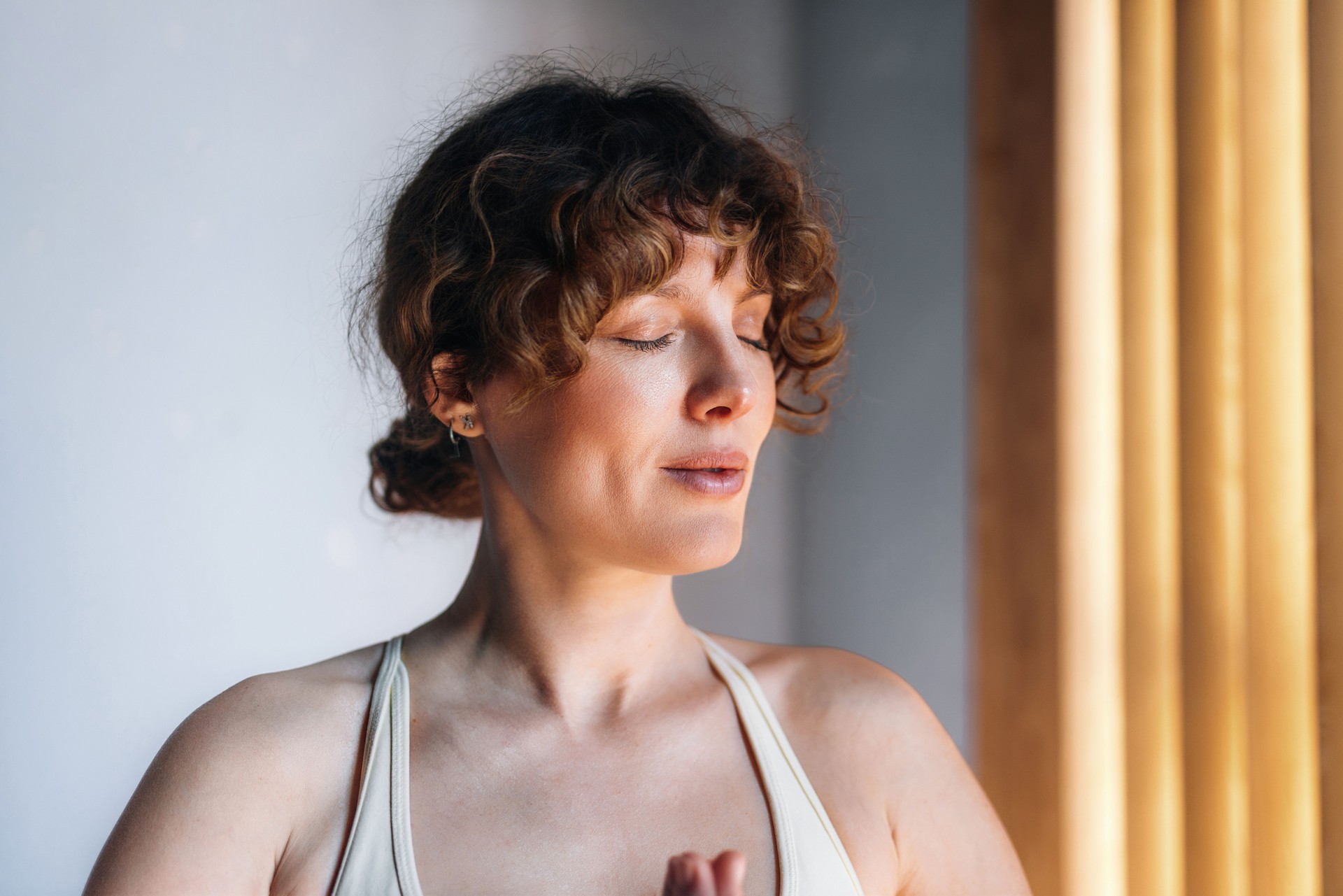 Serene Woman Practicing Meditation and Mindfulness in a Sunlit Room